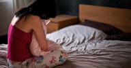 Image: Woman sitting on bed (© Leon Harris/cultura/Corbis Images)