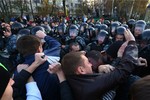 Protesters clash with police officers as they try to block the way during a protest in Moscow, Russia, Sunday, Oct. 13, 2013.