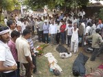 EDS NOTE: GRAPHIC CONTENT - Villagers stand near the bodies of victims of a stampede in Datia district in Madhya Pradesh state, India, Sunday, Oct. 13, 2013.