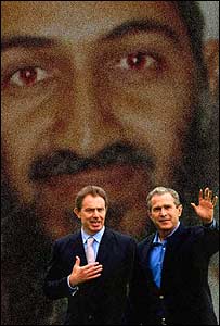 UK Prime Minister and US President George W Bush stand behind a picture of Osama Bin Laden