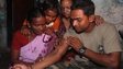 Indian police commando, Ganesh Raghunath Dhangade (R), shows a tatoo to his family in Thane district on the outskirts of Mumbai on October 16, 2013.