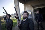 Free Syrian Army fighters look at a Syrian Army jet, not pictured, in Fafeen village, north of Aleppo province, Syria, Tuesday, Dec. 11, 2012.