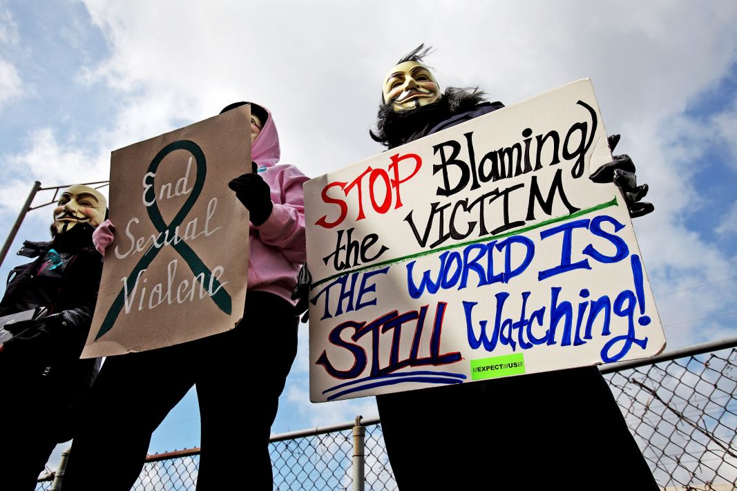 Protesters hold signs outside of the Jefferson County Justice Center and Jail in Steubenville, Ohio, on Wednesday, March 13, 2013. 