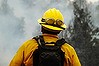 A firefighter watches flames grow after setting a backburn on Highway 190