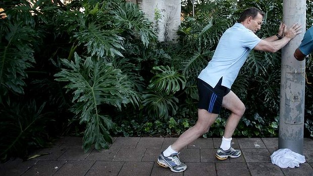 Opposition leader Tony Abbott stretches ahead of City2Surf in Sydney on Sunday.