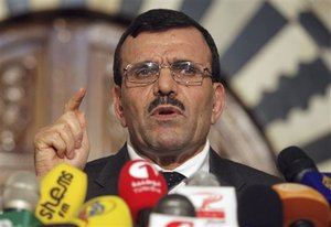 FILE- Tunisian Prime Minister Ali Larayedh addresses the media in this file photo dated Monday, July 29, 2013, in Tunis, Tunisia. It is announced Saturday Sept. 28, 2013, that Larayedh will step down in three weeks and negotiations will continue to find an interim replacement, after Tunisia's governing Islamist party agreed to resign in favor of a caretaker government to resolve the political crisis that has paralyzed the country.