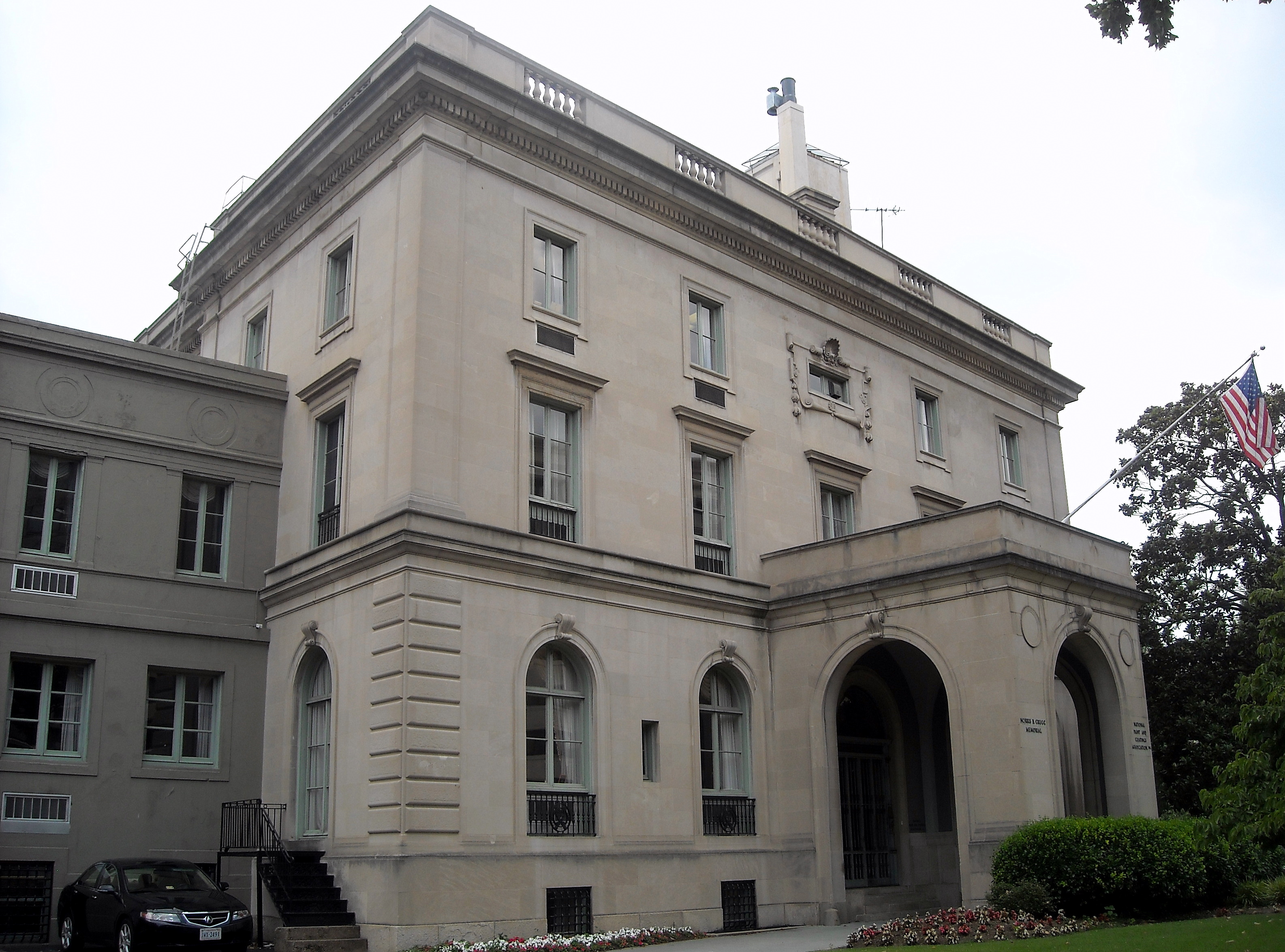 A three story gray mansion, with an impressive covered front entrance