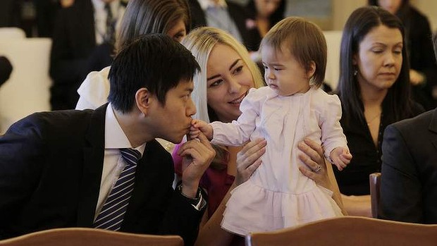 Albert Tse kisses his daughter Joesphine while waiting for Kevin Rudd to be sworn in as Prime Minister at Government House on Thursday morning.