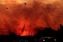 Helicopters drop water on a fire at Doyalson on the Pacific Highway as the sun goes down.