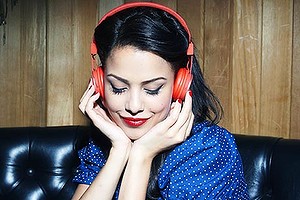 young woman listening to music wearing headphones