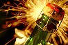 Champagne bottle with fireworks exploding behind.