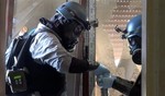 In this file image taken from video obtained from the Shaam News Network Thursday, Aug. 29, 2013, which has been authenticated based on its contents and other AP reporting, members of a chemical weapons investigation team take samples from the ground in the Damascus countryside of Zamalka, Syria.