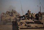 File - Israeli soldiers drive armored personal carriers during a military exercise in the Israeli-controlled Golan Heights near the border with Syria, Wednesday, Oct. 2, 2013.