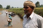 Dev Prasad from the village of Kerigada by the river which runs alongside his rice paddy. The crop will be ready for harvest in a month. The river is vital to his village's survival. It is used to irrigate crops year round, animals and bathed and watered in it, and women from the village wash clothes in its shallows. Mr Prasad's land, and the river, will be subsumed by a planned mine to be built by Thiess. PICTURE: Ben Doherty