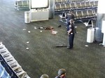 In this photo provided to the AP, which has been authenticated based on its contents and other AP reporting, police officers stand near an unidentified weapon in Terminal 3 of the Los Angeles International Airport on Friday, Nov. 1, 2013.