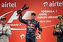 Red Bull driver Sebastian Vettel of Germany holds his trophy aloft after winning the Indian GP and, with it, the world championship. Mercedes driver Nico Rosberg of Germany (left) finished second and Lotus driver Romain Grosjean of France (right) third. 