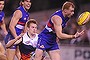 Cool running: Adam Cooney steals the ball from Adelaide's Sam Shaw. 