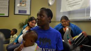 After receiving information about Health Care Reform, Paula Thornhill, 31, of Woodbridge, holding her daughter Serenity, waits for a relative to receive the same information as the Greater Prince William Community Health Center launched its education and enrollment services for the Virginia Health Insurance Marketplace on Tuesday, October 1, 2013, in Woodbridge, VA. In the background are Thornbill's son, Daniel, 2, Fatima Lopez of Manassas, and Roxana Hernandez with her son, Angel Rivas. The Center is the only agency certified by the Centers for Medicare and Medicaid Services (CMS) in Prince William County to enroll the public. (Photo by Jahi Chikwendiu/The Washington Post via Getty Images)