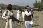 File - In this photo taken Sunday, Oct. 4, 2009, new Pakistani Taliban chief Hakimullah Mehsud, right, holds a rocket launcher with his comrades in Sararogha of Pakistani tribal area of South Waziristan along the Afghanistan border.