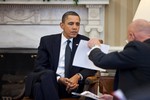 File - President Barack Obama studies a document held by Director of National Intelligence James Clapper during the Presidential Daily Briefing in the Oval Office, Feb. 3, 2011.