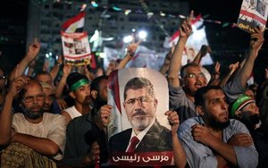 Supporters of Egypt's ousted President Mohammed Morsi chant slogans one holding a picture of Morsi with Arabic writing that reads: "Morsi is my president," at Nasr City, where protesters have installed a camp and hold daily rallies, in Cairo, Egypt, Monday, July 29, 2013.