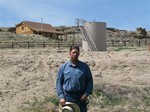 This May 22, 2009 picture shows John Fenton, a farmer who lives near Pavillion in central Wyoming, near a tank used in natural gas extraction, in background. Fenton and some of his neighbors blame hydraulic fracturing, or "fracking," a common technique used in drilling new oil and gas wells, for fouling their well water.