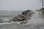 A house is engulfed by the storm surge brought about by powerful typhoon Haiyan that hit Legazpi city, Albay province Friday Nov.8, 2013 about 520 kilometers ( 325 miles) south of Manila, Philippines.