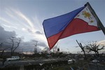 A Philippine flag stands amongst the damage caused after powerful Typhoon Haiyan slammed into Tacloban city, Leyte province, central Philippines on Saturday, Nov. 9, 2013.