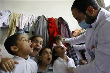 Syrian displaced children line up to receive vaccination against polio at one of the Syrian refugee camps in the southern port city of Sidon, Lebanon,...