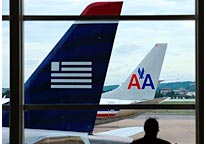 Image: (From left) A US Airways plane & an American Airlines plane sit near the gates at Ronald Reagan National Airport in Washington, DC (© Susan Walsh/AP)