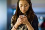 Pretty young lady using smartphone in a mall