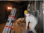 In this photo released by Tokyo Electric Power Co. (TEPCO), a worker operates an endoscope to take photos of water in the Unit 2 reactor's primary containment vessel at the the tsunami-crippled Fukushima Dai-ichi nuclear power plant in Okuma town, Fukushima Prefecture, northeastern Japan, Monday, March 26, 2012.