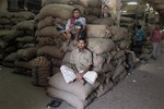 Bangladeshi shopkeepers sit on sacks at a wholesale market on the second day of a four-day general strike in Dhaka, Bangladesh, Monday, Nov. 11, 2013.