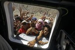 Desperate villagers rush to a window of a U.S. Navy Seahawk helicopter as crewmen deliver aid in an emergency drop in San Jose, Philippines, Monday, Nov. 18, 2013.