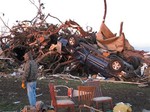 A man stands near a pickup that belonged to farmer Curt Zehr after a tornado blew through Zehr's farm on Sunday, Nov. 17. 2013.