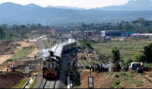 People watching a train running on the newly inaugurated KadurChikmagalur railway line at...