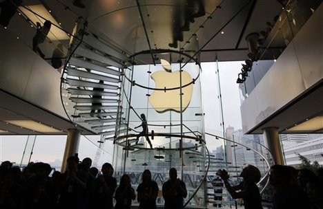 In this Friday, Sept. 21, 2012, file photo, staff members of Apple Inc. welcome customers as the Apple store in Hong Kong started selling iPhone 5.