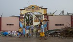 Filipino civilians walk out of what remains of the Guiuan East Central Elementary School after Super Typhoon Haiyan, Eastern Samar Province, 17 November, 2013.