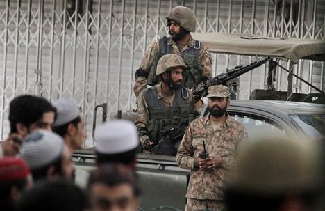 Pakistani military forces stand guard during the funeral of victims killed in sectarian clashes last Friday, in Rawalpindi, Pakistan, Sunday, Nov. 17, 2013.