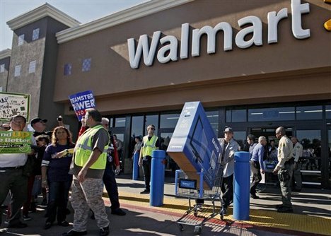 Shopper Jose Alvarez, right, carries out a newly-purchased television past protestors outside a Walmart store Friday Nov. 23, 2012, in Paramount, Calif. Wal-Mart employees and union supporters are taking part in today's nationwide demonstration for better pay and benefits A union-backed group called OUR Walmart, which includes former and current workers, staged the demonstrations and walkouts at hundreds of stores on Black Friday, the day when retailers traditionally turn a profit for the year.