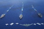 An Air Force B-2 bomber along with other aircrafts from the Air Force, Navy and Marine Corps fly over the Kitty Hawk, Ronald Reagan and Abraham Lincoln Carrier Strike groups.