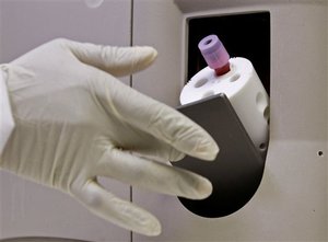 Health worker Xolisa Madikane, left unseen, tests blood for the HIV virus at a container lab next to the Gugulethu Community Health Clinic in Gugulethu on the outskirts of Cape Town, South Africa, Tuesday, July 21, 2009. South Africa launched a high-profile trial of an AIDS vaccine created by its own researchers Monday, a proud moment in a nation where government denial, neglect and unscientific responses have helped fuel the world's worst AIDS crisis.