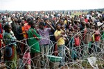 Internally displaced people gathered at Bangui's airport in Bangui, Central African Republic, Friday Dec. 6 2013, cheer at the sight of landing French military helicopters, a day after gun battle between Seleka soldiers and Christian militias left over 100 dead and scores wounded.