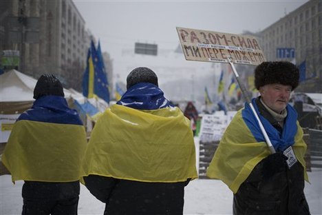 Pro-European Union activists wearing Ukrainian National flags walk through the Independence Square in KIev, Ukraine, Monday, Dec. 9, 2013.