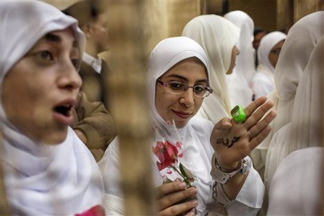 An Egyptian woman supporter of ousted President Mohammed Morsi shows her hand inscribed with the word "freedom," from inside the defendants' cage in a courtroom in Alexandria, Egypt, Saturday, Dec. 7, 2013.