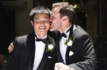 In this Dec. 7, 2013 file photo, Ivan Hinton, right, gives his partner Chris Teoh a kiss after taking their wedding vows during a ceremony at Old Parliament House in Canberra, Australia.