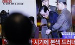 A man watches a live TV news program showing that North Korean leader Kim Jong Un's uncle Jang Song Thaek, second from right, is escorted by military officers during a trial in Pyongyang, North Korea Thursday, Dec. 12, 2013