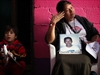 Tomasa Guzman Flores, right, with a photo of her missing son in Mexico