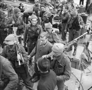 A German prisoner, Unteroffizier Leo Marsiniak, being escorted at Newhaven. He was captured at the gun battery at Varengeville by No. 4 Commando.