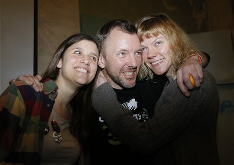 From left: Greenpeace International activists Camila Speziale of Argentina, Phiip Ball of the United Kingdom and Sini Saarela of Finland pose during their meeting with residents of St.Petersburg, Russia, Monday, Dec. 23, 2013.